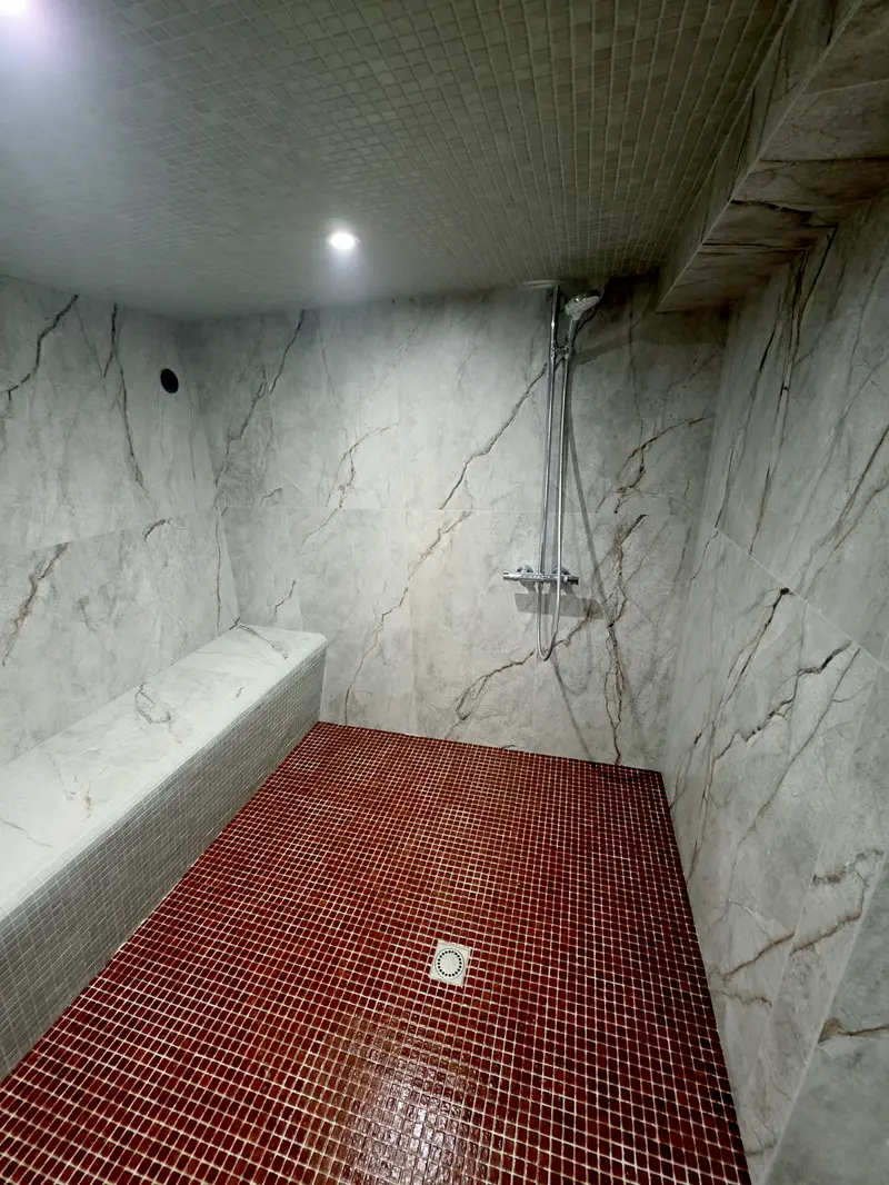 La même pièce d'eau terminée, marbre au mur et au plafond, mosaïque au sol et sur le banc