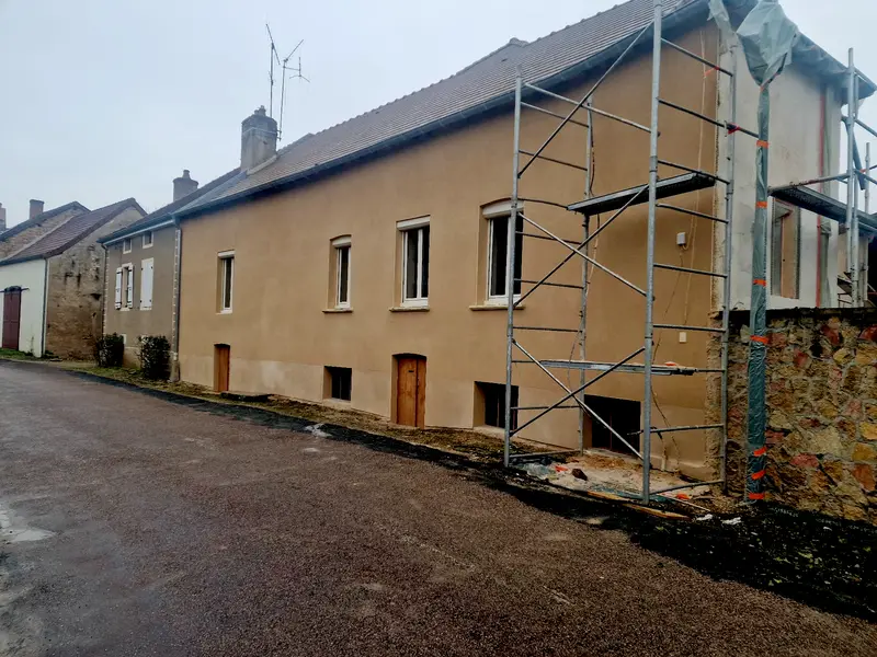 Même façade avec l'enduit de finition posé, échafaudage encore en place